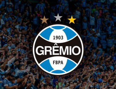 Escudo do Grêmio com torcedores ao fundo